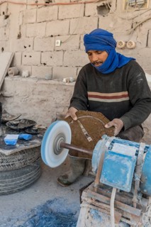 Bedouin preparing stone slabs with fossils