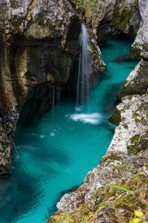 Emerald green wild river Soca flows through rocky gorge