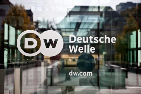 Logo Deutsche Welle at the glass door to the headquarters of the company