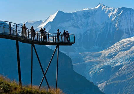 Tourists on the observation deck of the First Cliff Walk by Tissot in front of the Fiescherhorn north face and the Grindelwald glacier