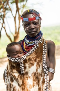 Young woman with toddler in traditional clothes made of goatskin