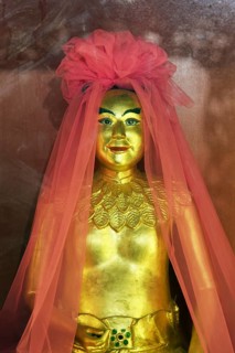 Golden god figure with pink veil