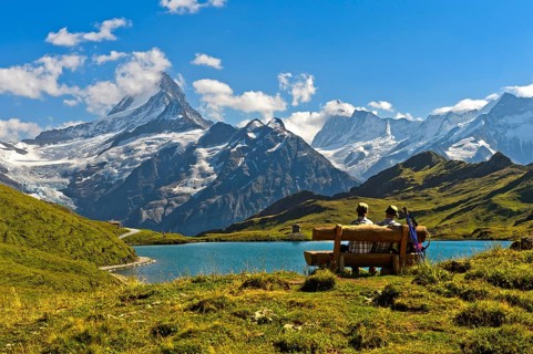 Hikers pausing on a wooden bench at lake Bachalpsee