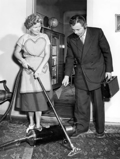 Representative and housewife with vacuum cleaner