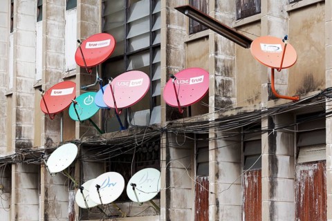 Colourful satellite dishes on a building