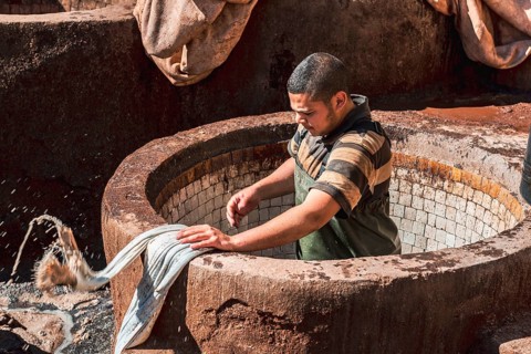 Worker dyeing leather