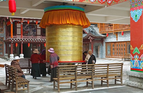 Women turn a prayer wheel