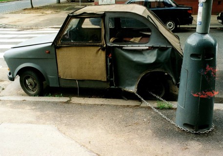 Broken car chained to a lamppost ca. 1970s