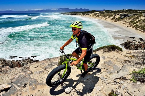 Mountain biker with Fatbike on cliff