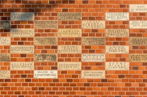 Memorial donor plaques on brick wall of Wawel Castle in Krakow
