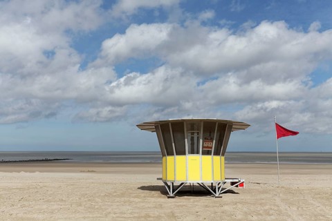 Sandy beach with modern beach guard hut