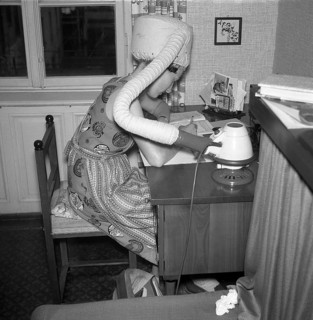 A woman dries her hair at the desk