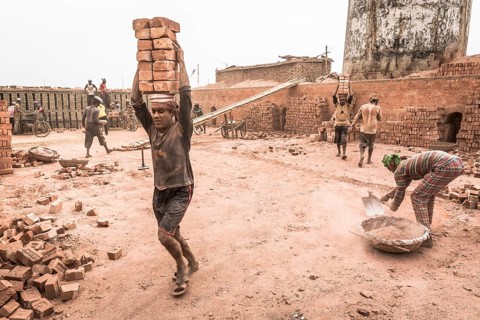Workers with bricks on their heads in the brickyard