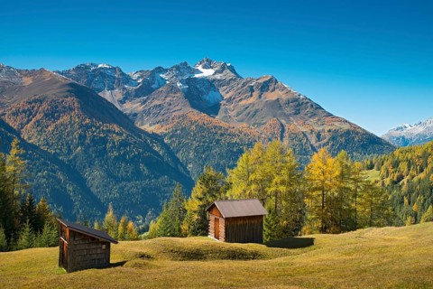 Autumnal mountain landscape with alpine huts
