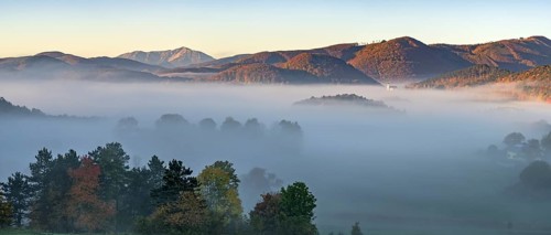Autumn foggy atmosphere with Schneeberg and pilgrimage church Hafnerberg