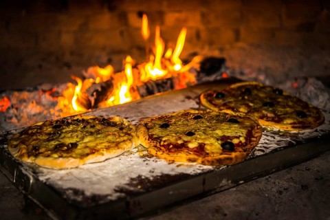 Pizza is baked in a pizza oven