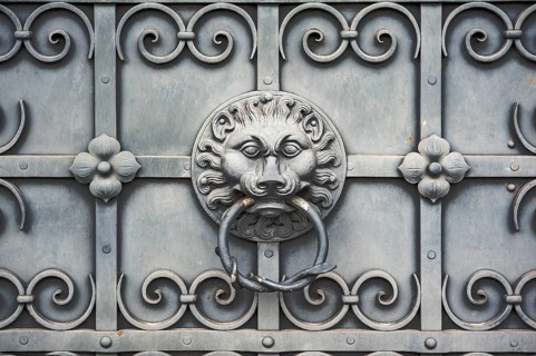 Iron gate with lion's head as door knocker