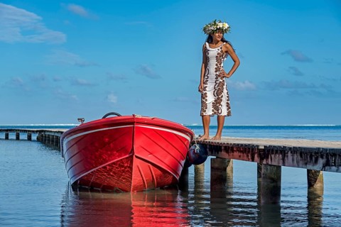 Young woman with flower wreath next to boat