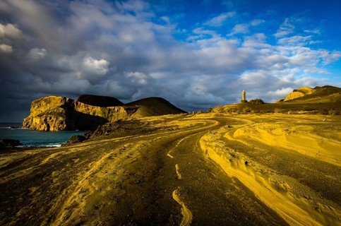 Rocky coast with lighthouse Farol da Ponta dos Capelinhos