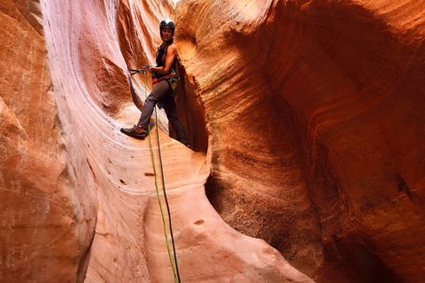 Woman climbing in Huntress Slot Canyon outside Zion National Park