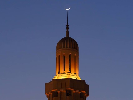 Crescent Moon over Illuminated Minaret