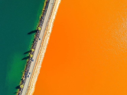 Street trough orange and blue lakes in mining region