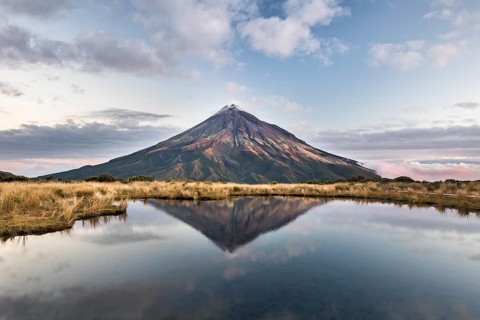 Stratovolcano Mount Taranaki or Mount Egmont reflected in Pouakai Tarn