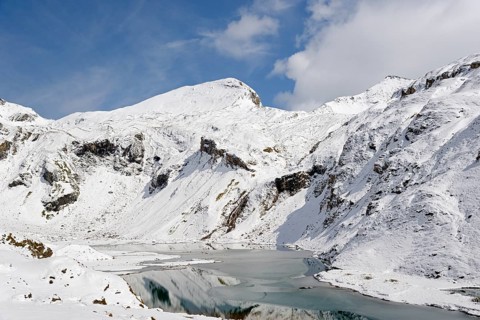 Nassfeld reservoir at 2233 m on the Grossglockner High Alpine Road with snowy mountains