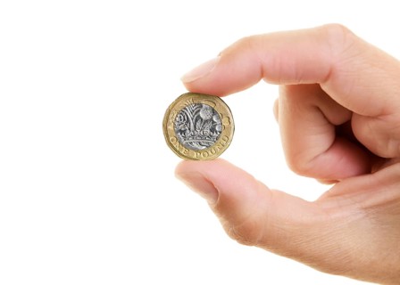 New Pound Coin held between the fingers of a womans hand
