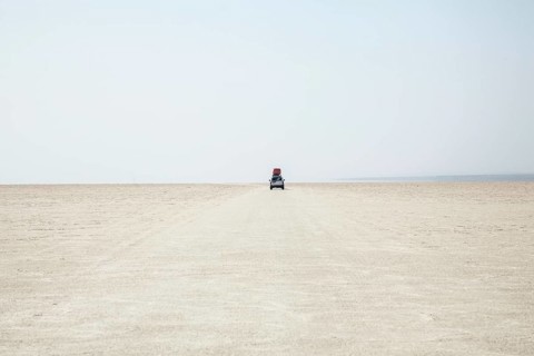 Off-road vehicle drives through the salt desert of Dallol