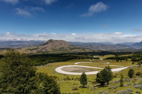 Curvy road Carretera Austral leads through green hillside