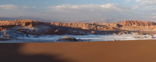 Giant dunes and bizarre red rock formations with white salt at sunset