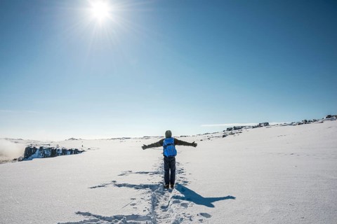 Young man walks through snowy countryside