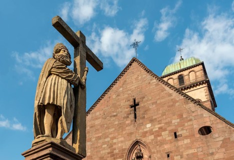 Statue on top of Emperor Constantin Fountain in front of Sainte Croix church in Kaysersberg