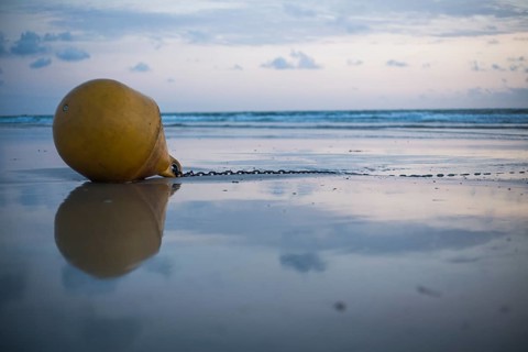 Buoy on the beach at sunset