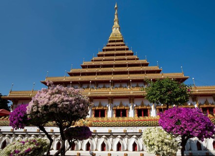 Flowering bushes in front of nine-story stupa Phra Mahathat Kaen Kakhon