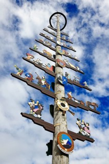 Maypole with guild sign in front of cloud sky