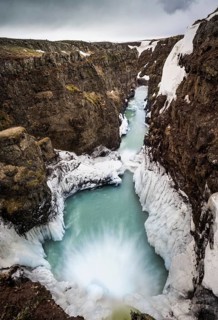 Partially icy waterfall in a canyon