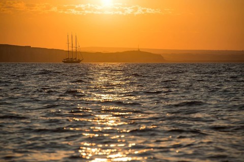 Three masters off the coast at sunrise