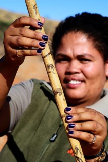 Ranger of the !Xaus Lodge shows her walking stick with aardvark and anteater decoration