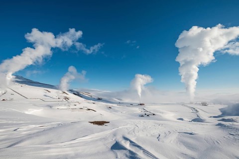Rising steam in snowy landscape