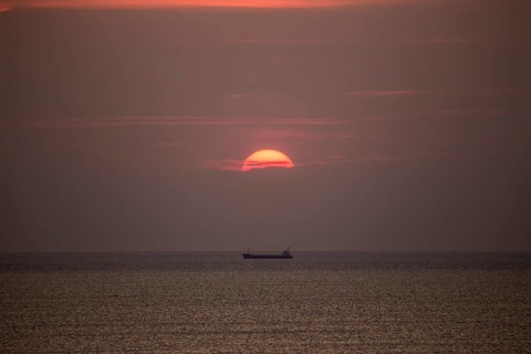 Mediterranean sea with cargo ship in the sunset at Tarragona