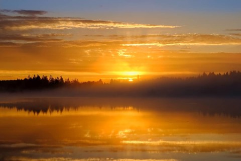 Sunrise with early morning mist over Kirchsee with Reutberg Monastery