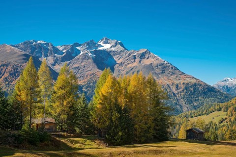Autumnal mountain landscape with alpine huts