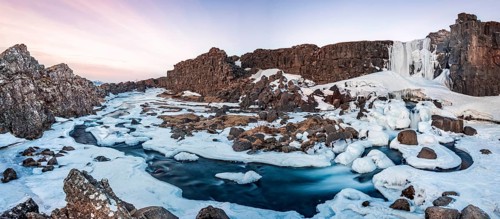 Partially frozen waterfall Oxararfoss in winter