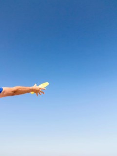 Man catching a frisbee against blue sky
