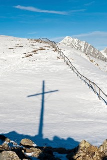 Shadow of summit cross in the snow