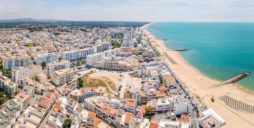 White architecture and blue Atlantic ocean in Quarteira resort during sunny day
