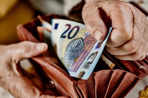 Senior citizen pulls a 20 euro note from her wallet