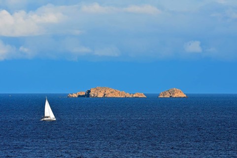 Sailboat in front of rocky islands